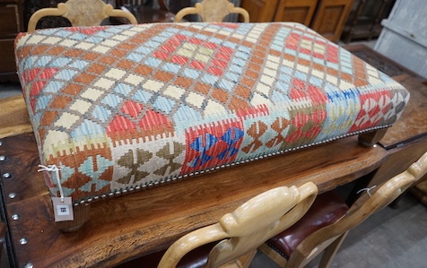 A rectangular Kelim footstool on oak feet, length 114cm, depth 60cm, height 30cm